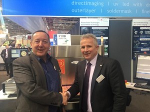 Neil Martin and Thomas Kunz the owner of Schmoll Maschinen GmbH, at Productronica Munich excepting the third MDI sold to Merlin.